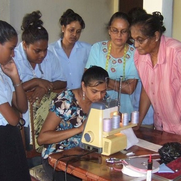 Nanaimo Sewing School Students, under the watchful eyes of Mrs. Habbibullah, right, using the "serger" sewing machine for the first time.