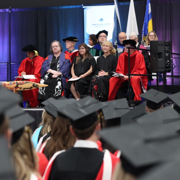 Dr. Dave Hopwood (green gown) as a member of the stage party. June 22, 2023.