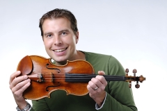 James Mark Man holding up a violin.