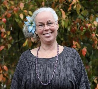Smiling woman wearing glasses and a grey sweater